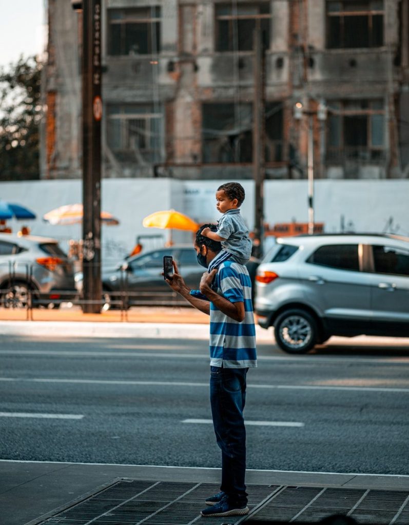 man in blue and white plaid dress shirt and blue denim jeans holding yellow umbrella