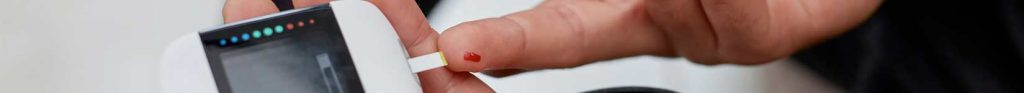 man with diabetes demonstrating blood glucose testing using gluco-meter